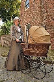 Afbeelding van een ouderwetse vrouw met een oude kinderwagen